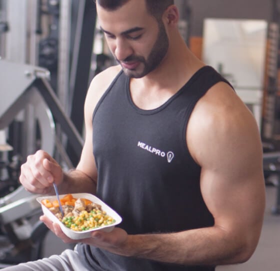 person sitting on a gym bench eating delicious fitness food