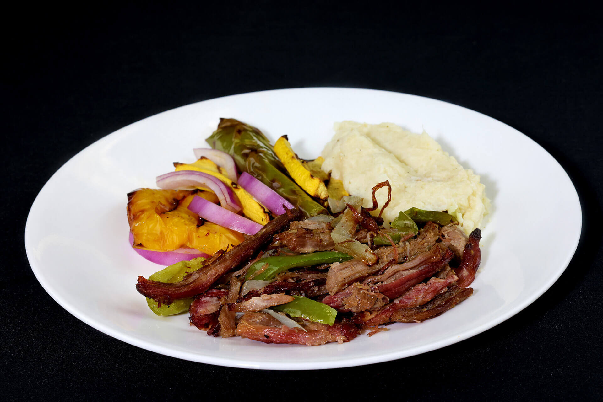 Paleo pulled steak with cauliflower mash, bell peppers, onions, and parsley.