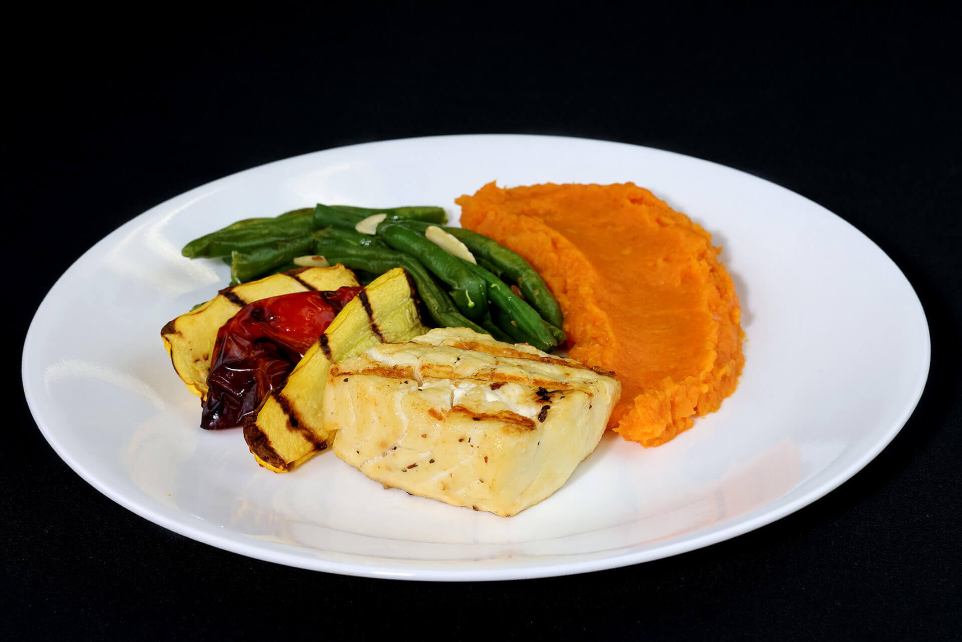 Paleo white fish and yam mash, roasted bell peppers, and green beans, topped with almonds.