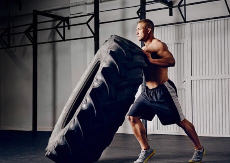 High Intensity Athlete is Working on Lifting a Tire