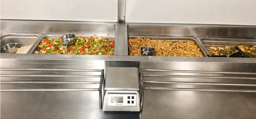 MealPro kitchen staff portioning a meal based on customer specifications MealPro kitchen staff portioning a meal based on customer specifications