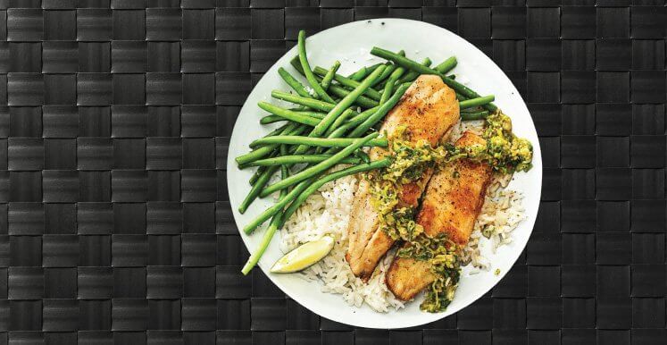 Roasted tilapia with string beans served over a bed of brown rice.