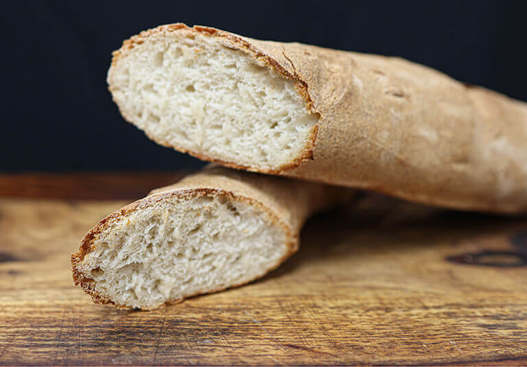 fresh baked baguette cut on cutting board