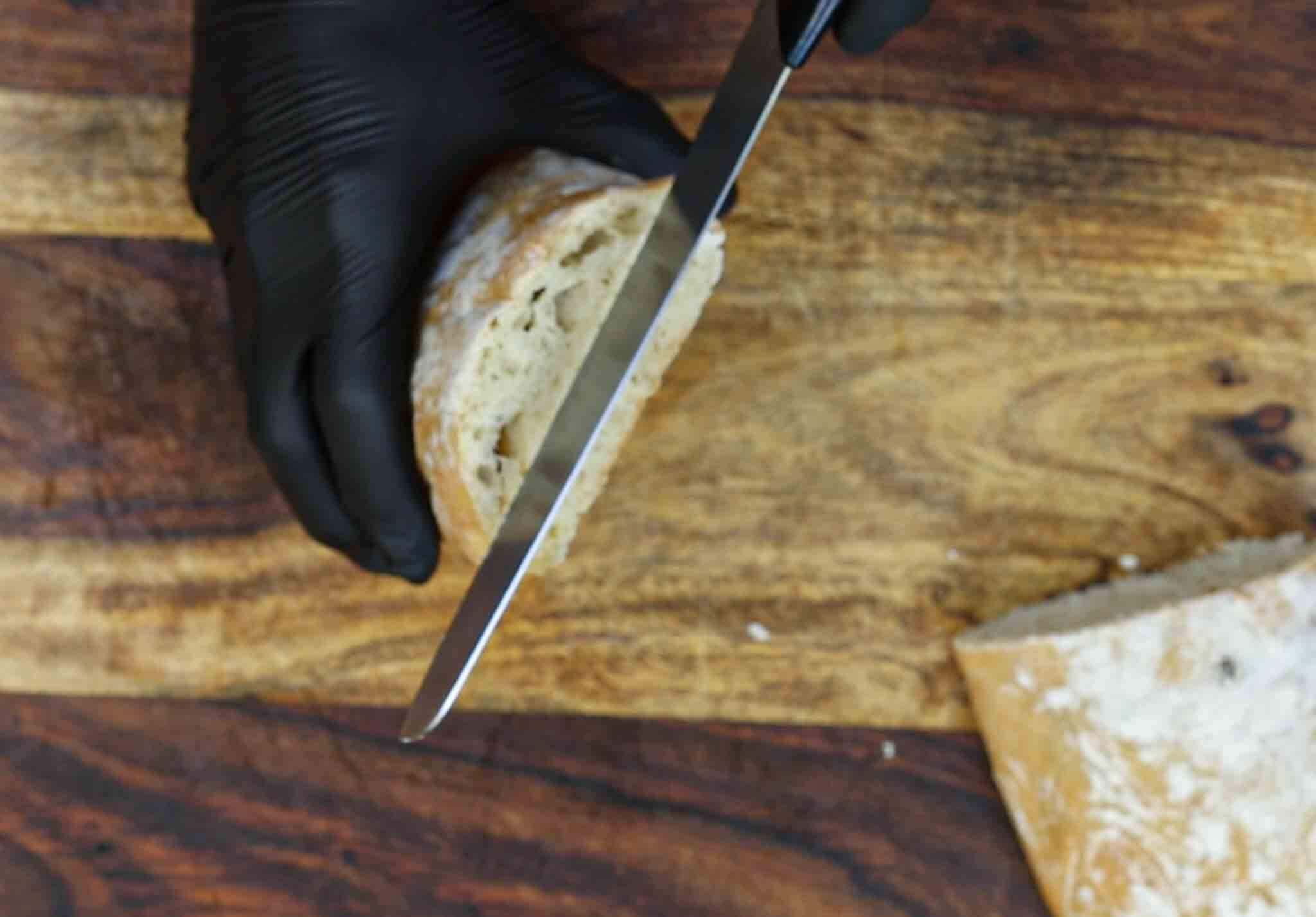 chef prepares to slice ciabatta bread